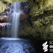 Smoo Cave waterfall with Scottish Geology Trust logo in white