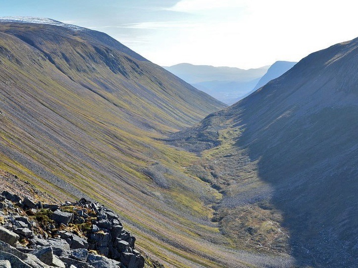 The long glacially eroded trough of the Lairig Ghru follows one of several NNE-trending lines of weakness that cut across the Cairngorms Pluton. The glacially steepened valley sides are now covered by scree and active debris flows.