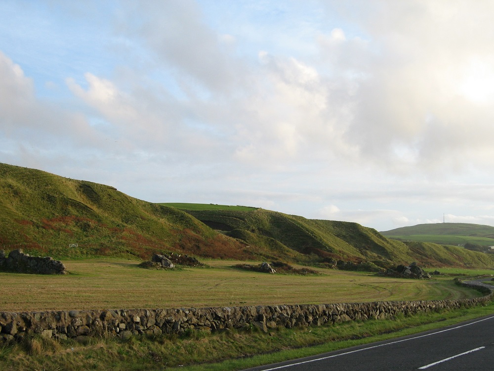 Raised Beach and relict sea cliff, to the south of Bennane Head, Ballantrae. The rocky outcrops protruding from the gently sloping raised beach are the remains of sea stacks.